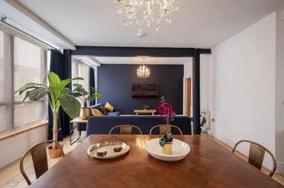a dining room with a table and a blue couch at Blueberries Apartments by Sasco in Blackpool