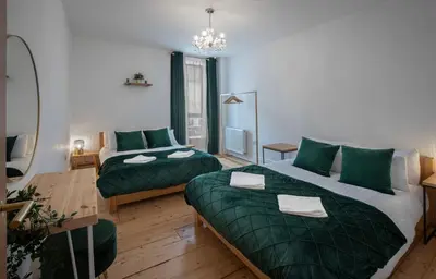a bedroom with two beds and a living room at Blueberries Apartments by Sasco in Blackpool