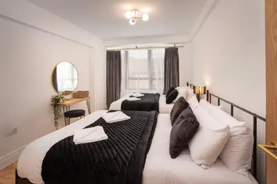 a hotel room with two beds and a mirror at Blueberries Apartments by Sasco in Blackpool