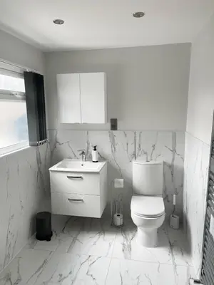a white bathroom with a toilet and a sink at Smith Stayz Apartments in Blackpool
