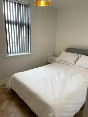 a white bed in a room with a window at Smith Stayz Apartments in Blackpool