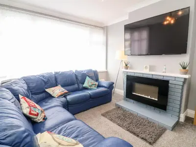 a living room with a blue couch and a tv at 71 Nutter Road in Cleveleys