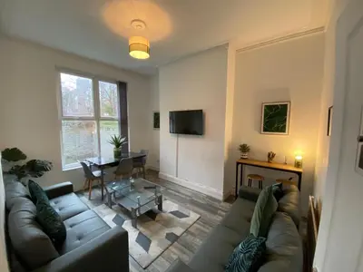 a living room with a couch and a table at Huge 7 Bed Home For Groups in Liverpool