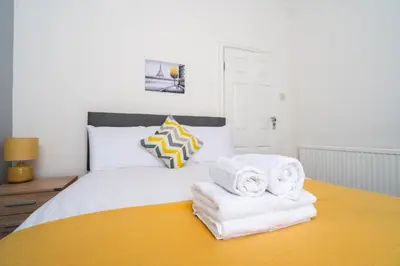 a bedroom with a bed with towels on it at Huge 7 Bed Home For Groups in Liverpool