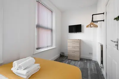 a room with a bed with white towels on it at Huge 7 Bed Home For Groups in Liverpool