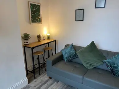 a living room with a couch and a table at Huge 7 Bed Home For Groups in Liverpool