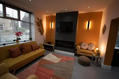 a living room with two couches and a flat screen tv at Ideal Lodgings in Accrington in Accrington
