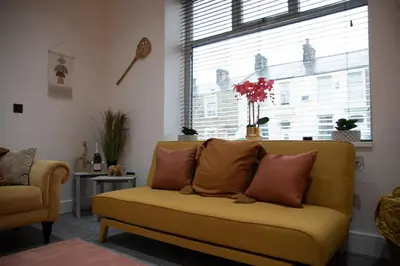 a living room with a yellow couch and a window at Ideal Lodgings in Accrington in Accrington