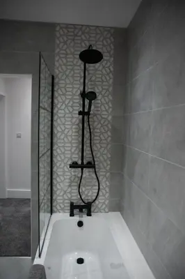 a bath tub with a shower in a bathroom at Ideal Lodgings in Accrington in Accrington