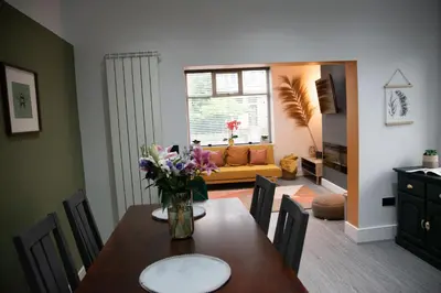 a dining room with a table with flowers on it at Ideal Lodgings in Accrington in Accrington