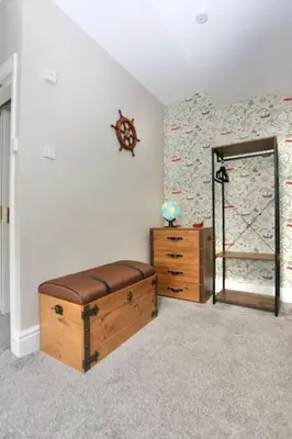 a room with a bed and a mirror and a dresser at The Hot Tub Townhouse by Holiday Heim in Lytham St Annes