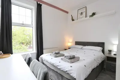 a bedroom with a large white bed and a window at The Hot Tub Townhouse by Holiday Heim in Lytham St Annes