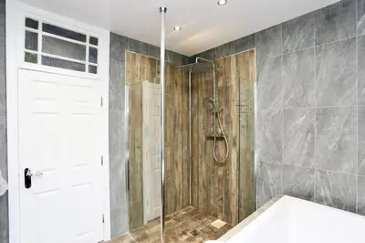 a bathroom with a shower with a glass door at The Hot Tub Townhouse by Holiday Heim in Lytham St Annes