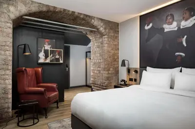 a hotel room with a bed and a chair at Radisson RED Hotel, Liverpool in Liverpool
