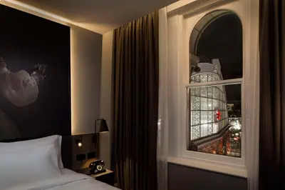 a bedroom with a bed and a window with a cage at Radisson RED Hotel, Liverpool in Liverpool