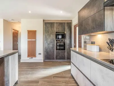 a kitchen with wooden cabinets and a counter top at Haven Cottage in Blackburn