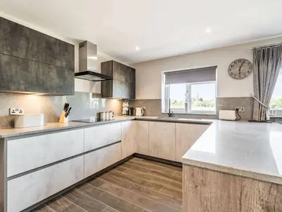 a kitchen with stainless steel appliances and a window at Haven Cottage in Blackburn