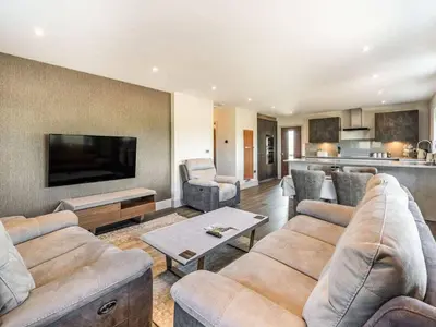 a living room with two couches and a tv at Haven Cottage in Blackburn