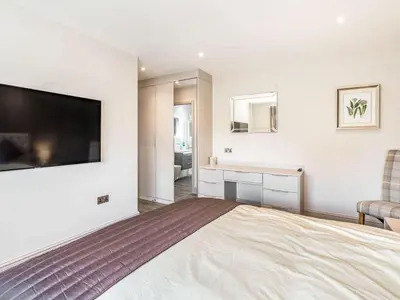 a bedroom with a large bed with a flat screen tv at Haven Cottage in Blackburn