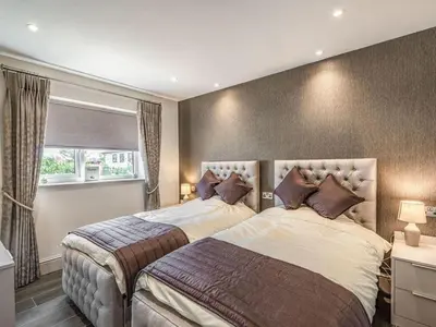 a bedroom with two beds and a window at Haven Cottage in Blackburn