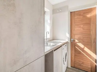 a kitchen with a sink and a washing machine at Haven Cottage in Blackburn