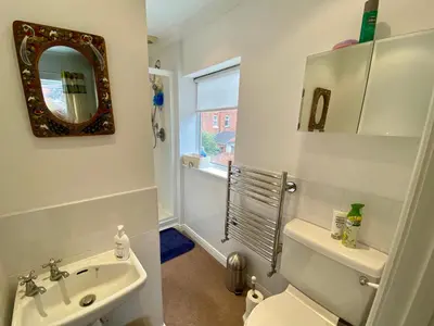 a bathroom with a sink and a toilet and a mirror at Spacious Two Bedroom House - TM in Southport