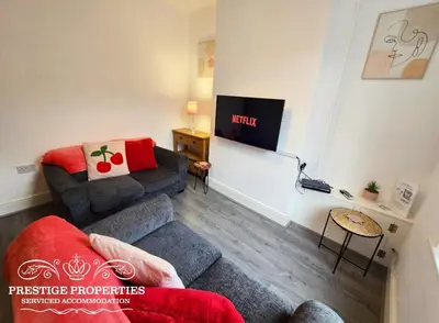 a living room with a couch and a tv at Cross Street by Prestige Properties SA in Barrow in Furness
