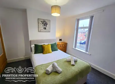 a bedroom with a bed with two towels on it at Cross Street by Prestige Properties SA in Barrow in Furness