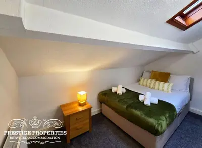 a bedroom with a bed and a nightstand with a bed sidx sidx sidx sidx at Cross Street by Prestige Properties SA in Barrow in Furness