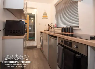 a kitchen with a sink and a stove top oven at Cross Street by Prestige Properties SA in Barrow in Furness