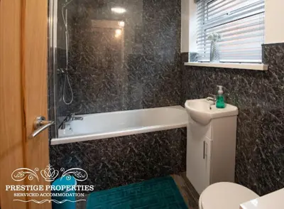 a bathroom with a tub and a toilet and a sink at Cross Street by Prestige Properties SA in Barrow in Furness
