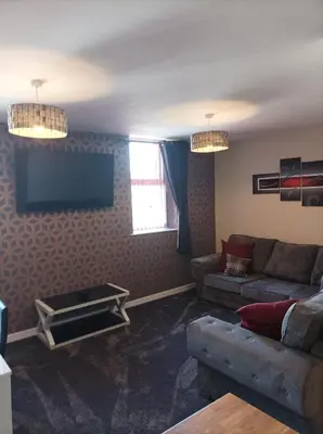 a living room with a couch and a flat screen tv at Rose James Apartments in Blackpool