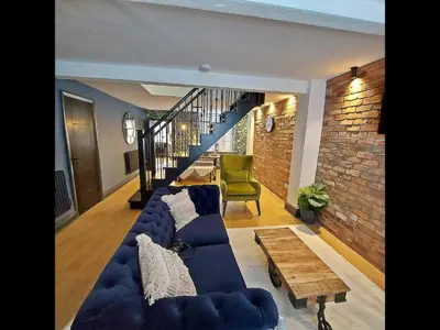 a living room with a blue couch and a table at Boutique cottage set in historic town of Clitheroe in Clitheroe