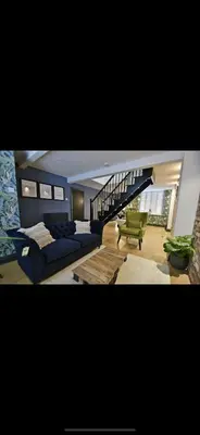 a living room with a blue couch and a staircase at Boutique cottage set in historic town of Clitheroe in Clitheroe
