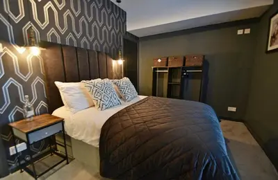 a bedroom with a bed and a side table at Boutique cottage set in historic town of Clitheroe in Clitheroe