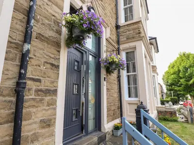 a house with a blue door with flowers on it at 112 Balmoral Road in Morecambe