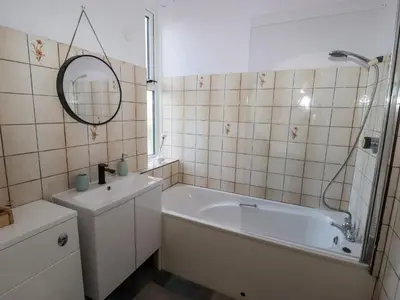 a bathroom with a tub and a sink and a mirror at 112 Balmoral Road in Morecambe