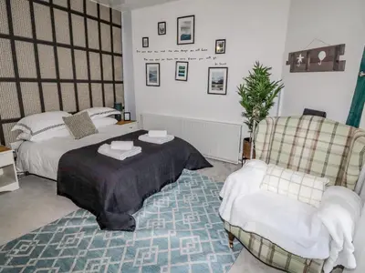 a bedroom with two beds and a table and a chair at 112 Balmoral Road in Morecambe
