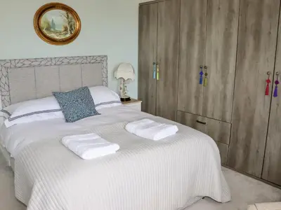 a bedroom with a white bed with two towels on it at 112 Balmoral Road in Morecambe