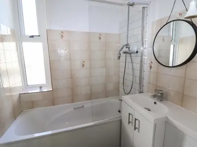 a bathroom with a tub and a sink and a mirror at 112 Balmoral Road in Morecambe