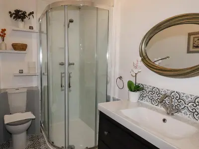 a bathroom with a shower and a sink and a mirror at 112 Balmoral Road in Morecambe