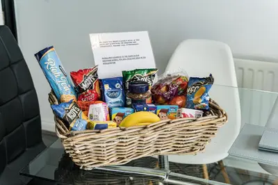a basket of chips and snacks on a table at warm modern 3 bedroom house free secure off road parking, wifi & sky sleep upto 6 guest 2 bathrooms in Aintree