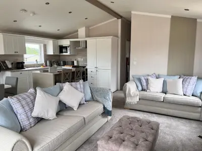 a living room with two couches and a kitchen at Edmonton Lodge in Clitheroe