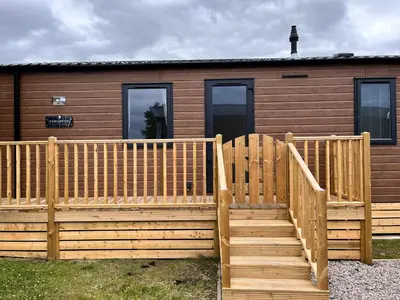 a house with a wooden fence and stairs in front of it at Edmonton Lodge in Clitheroe