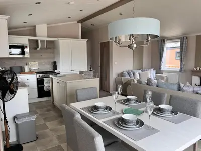 a kitchen and a living room with a table and chairs at Edmonton Lodge in Clitheroe