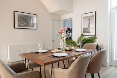 a dining room with a wooden table and chairs at The Callie by Sasco Apartments in Blackpool