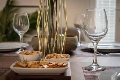 a table with a plate of food and wine glasses at The Callie by Sasco Apartments in Blackpool