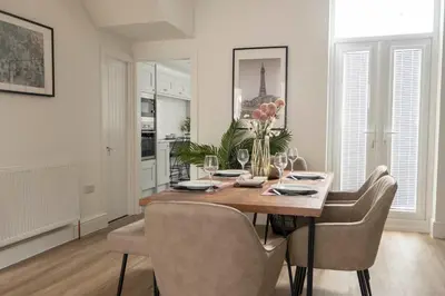 a dining room with a wooden table and chairs at The Callie by Sasco Apartments in Blackpool