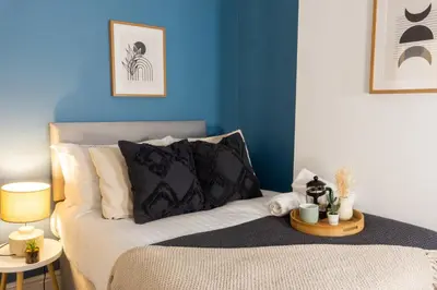 a bedroom with a bed with a blue wall at Coningsby House - Air Host & Stay - 6BR, Sleeps 14 in Liverpool
