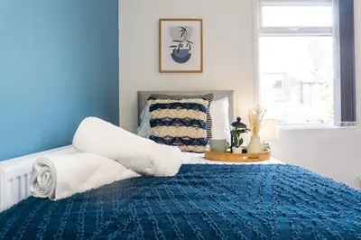a blue and white bedroom with a bed and a window at Coningsby House - Air Host & Stay - 6BR, Sleeps 14 in Liverpool